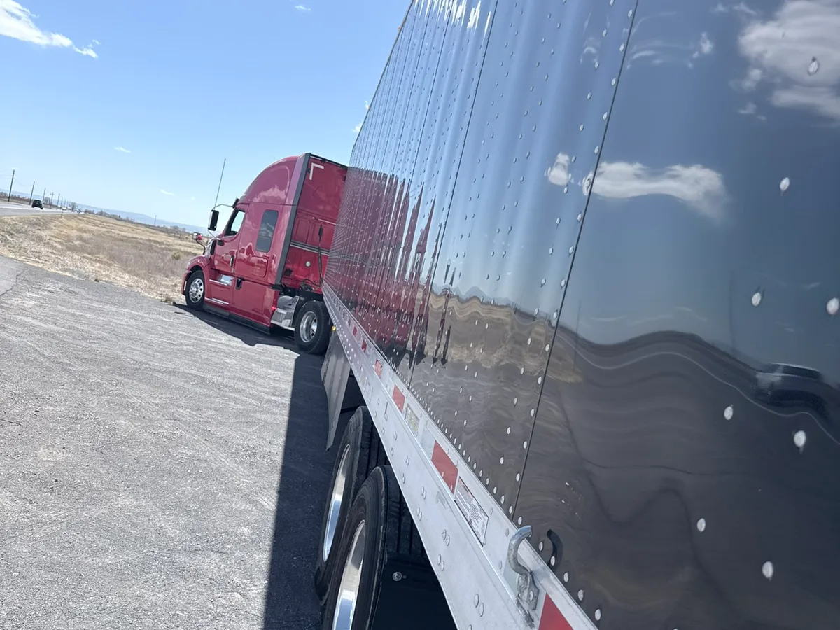 Fire Chief Transport's red tractor and dry van trailer on the road