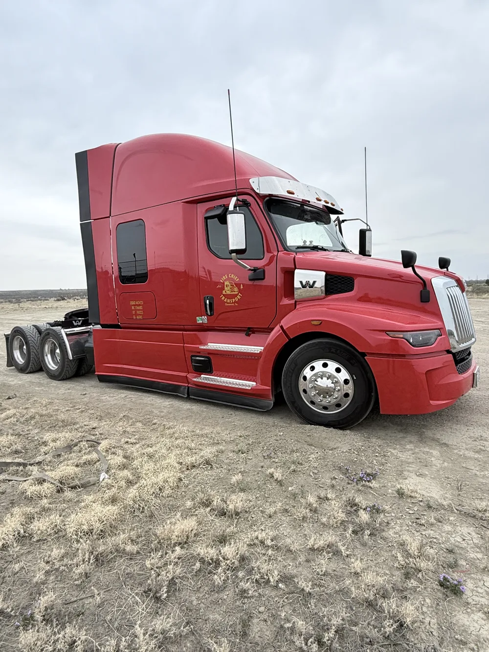 Red truck and trailer on an open prairie highway